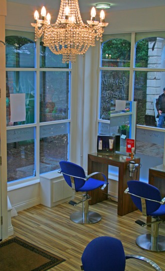 The chandelier in the bay window, over a row of royal blue chairs